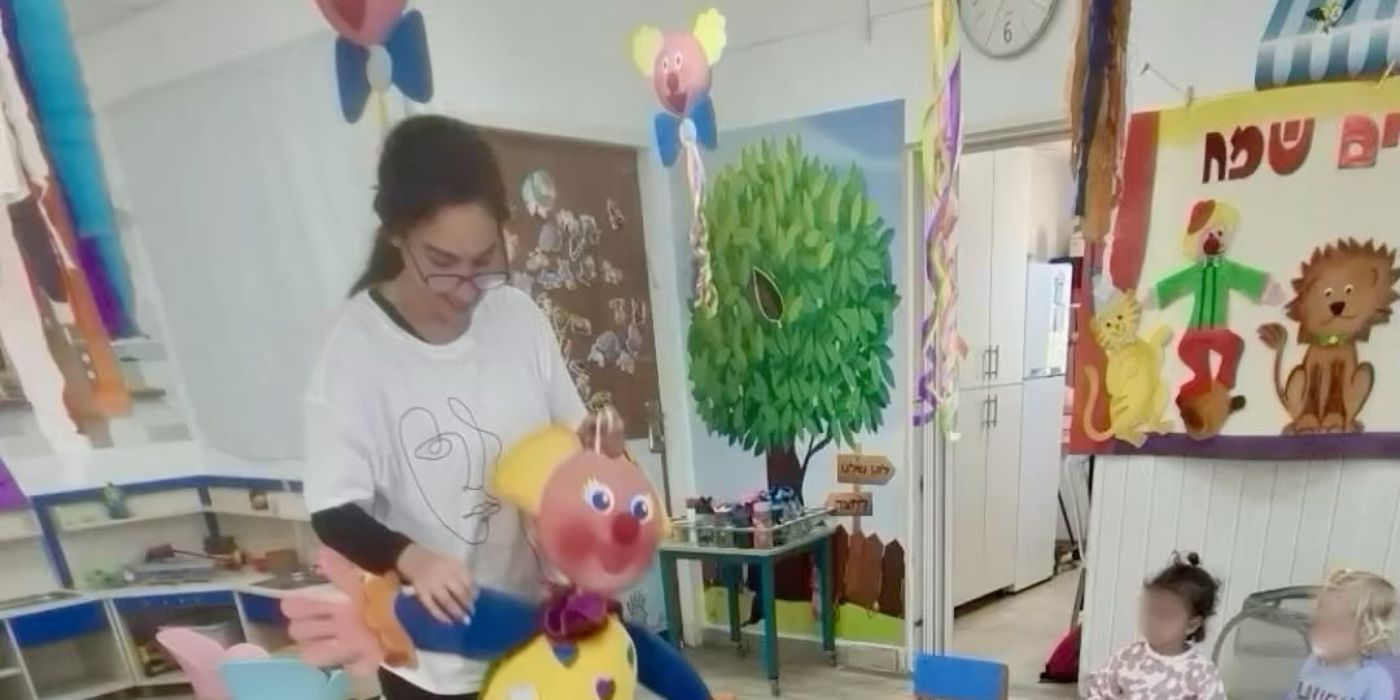 אשת צוות מציגה בובה גדולה לילדים במפגש