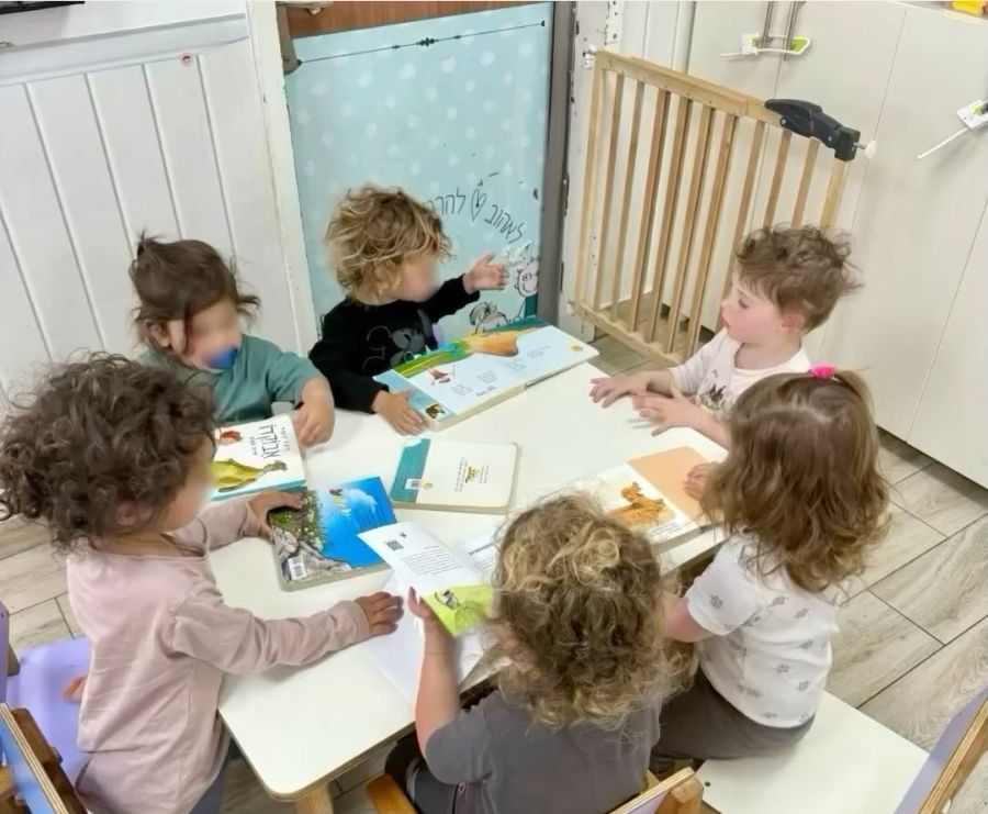 ילדים סביב שולחן בעבודה בקבוצה קטנה