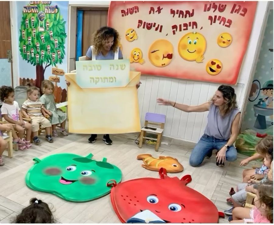 מפגש לקראת ראש השנה, מול שלט שנה טובה ומתוקה