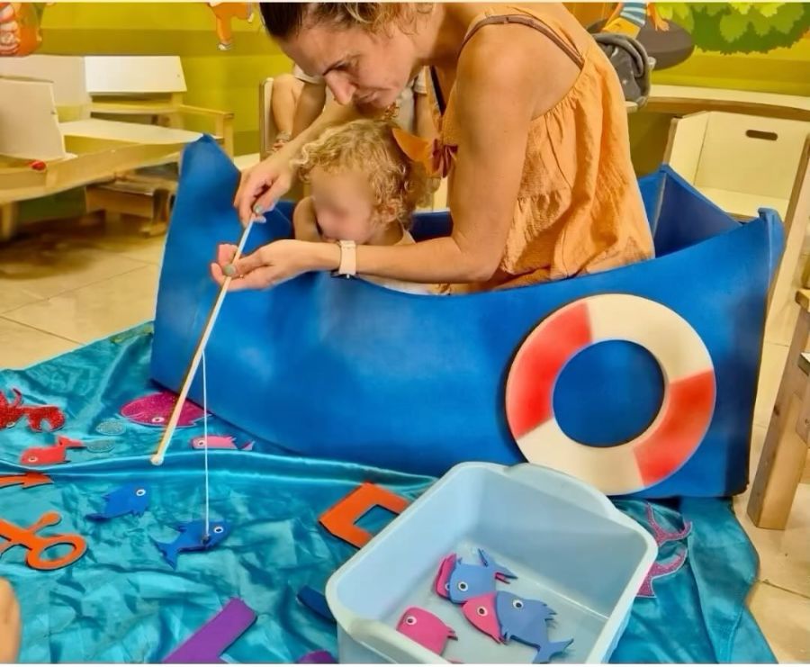 אשת צוות וילד בסירת משחק עם חכה