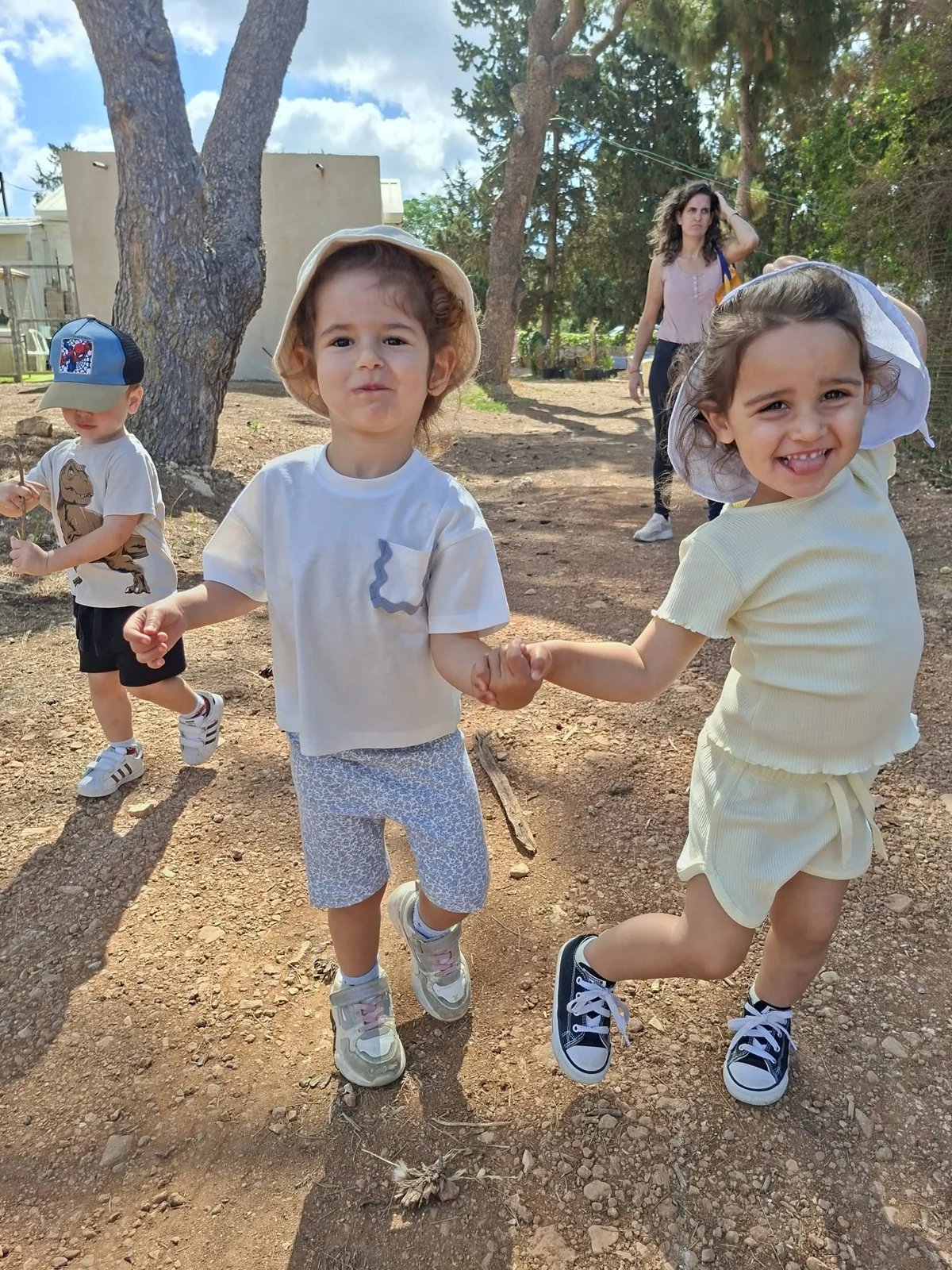שני ילדים מחזיקים ידיים בטיול של גן חלום ילדות